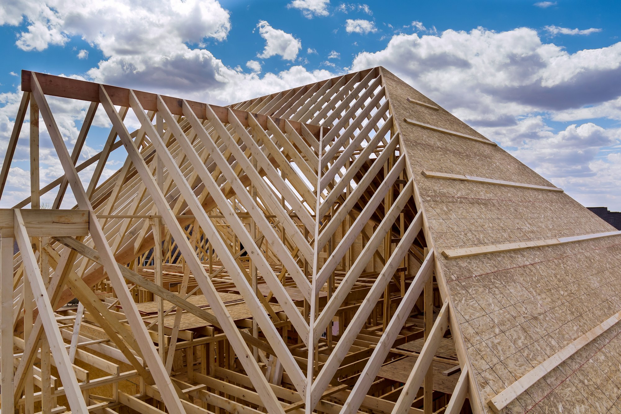 Panorama top view of closeup new wooden roof beams built home under construction under framing